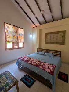 a bedroom with a bed and two windows and a table at Veridian Bloom in Ahungalla