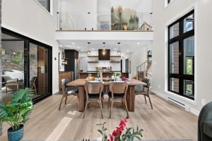 a dining room and kitchen with a table and chairs at Alta Vita Ste-Adèle Modern, Forest, Spa and Sauna in Sainte-Adèle