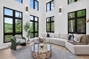 a living room with a couch and a table at Alta Vita Ste-Adèle Modern, Forest, Spa and Sauna in Sainte-Adèle