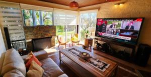 a living room with a couch and a flat screen tv at Retiro de Las Cañas in Fray Bentos