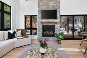 a living room with a couch and a fireplace at Alta Vita Ste-Adèle Modern, Forest, Spa and Sauna in Sainte-Adèle +61 photos