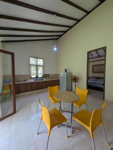 a room with a table and chairs and a kitchen at Veridian Bloom in Ahungalla