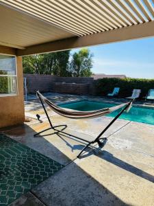 a hammock on a patio next to a swimming pool at Desert Vista View in Desert Hot Springs