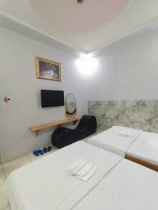 a hotel room with two beds and a desk at Khách Sạn Lâm Tiên - Lam Tien Hotel in Bùi Tiếng