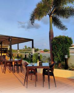 eine Terrasse mit Tischen und Stühlen und einer Palme in der Unterkunft Ferra Premier by JG in Boracay