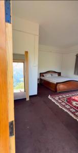 an empty room with two beds and a window at Nivriti Stays in Nainital