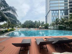 a large swimming pool with chairs and a building at Vinhomes D'capitale Hanoi Opus in Hanoi