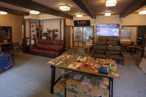 a living room with a table and a tv at Kusatsu Onsen Eidaya in Kusatsu
