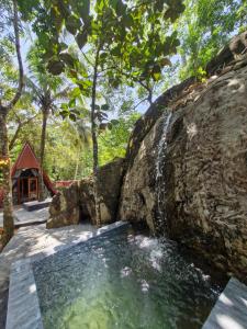 a waterfall on a rock in front of a house at Dhunhill Garden in Avissawella