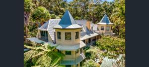 an aerial view of a house with turrets at Gorge Castle in forest landscape in Galston