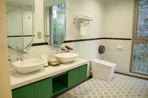a bathroom with two sinks and a toilet at Samten Hills Villa Dalat in Xuan An