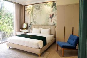 a bedroom with a large bed and a blue chair at Samten Hills Villa Dalat in Xuan An