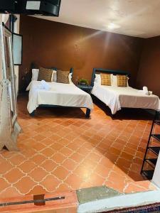 a room with two beds in a room with a floor at Hotel kasa Sarita Centro Historico SMA in San Miguel de Allende