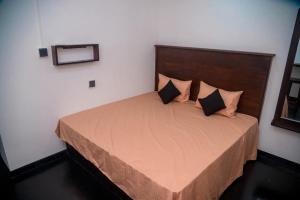 a bedroom with a large bed with two pillows at Dhunhill Garden in Avissawella