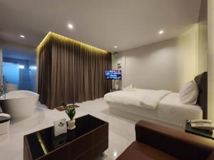 a bedroom with a bed and a tub and a television at PVILLA in Ban Phraek Sa