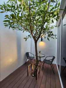 a tree in a room with two chairs and a table at PVILLA in Ban Phraek Sa