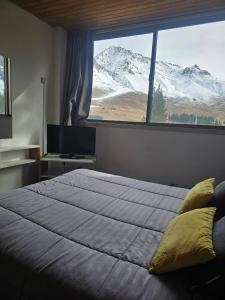 a bedroom with a large bed and a large window at Depto 7 personas - Edificio Cirrus in Las Lenas