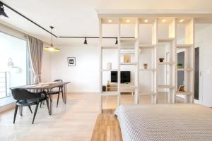 a bedroom with a bed and a table and a room at Yeosu Harushimpyo Pension in Yeosu