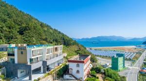 an aerial view of a building next to the ocean at Yeosu Harushimpyo Pension in Yeosu