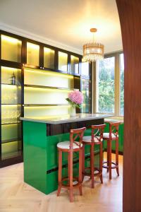 a kitchen with a green island with stools at Samten Hills Villa Dalat in Xuan An