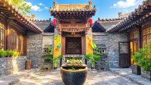 a building with a fountain in front of it at Elsewhere Hotel Inn Ancient City Center Branch in Pingyao