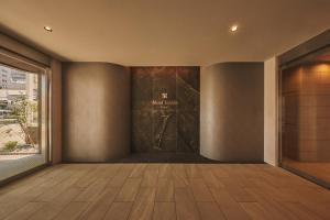 a hallway with a door with a painting on the wall at Moat Inside Hakata in Fukuoka