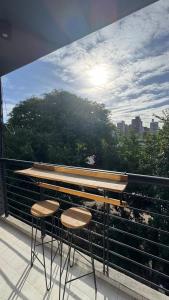 a balcony with two stools and a view of a city at 9 de Julio Park Suites in San Miguel de Tucumán