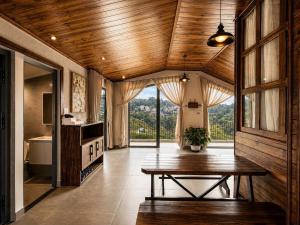 a dining room with a table and a large window at An Valley Villa Đà Lạt in Da Lat