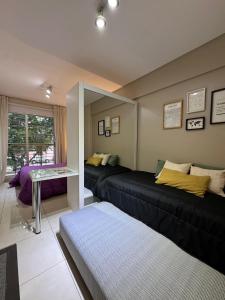 a living room with a black couch and a table at 9 de Julio Park Suites in San Miguel de Tucumán