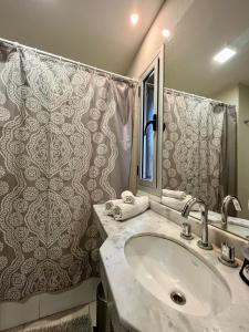 a bathroom with a sink and a shower at 9 de Julio Park Suites in San Miguel de Tucumán +41 photos