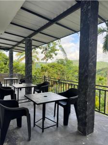 a patio with tables and chairs on a balcony at Gagana Vila 01 in Kandy