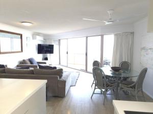 a living room with a couch and a table at Pandanus Shores Kings Beach in Caloundra
