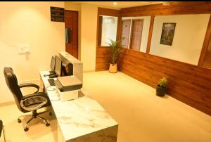 an office with a desk with a computer and a chair at Hotel Layover Stay-3 Minutes From the Airport in Jaipur
