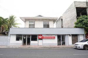a white building with a car parked in front of it at En Pensionne Comfort in Iloilo City