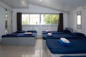 a room with three beds and a window at En Pensionne Comfort in Iloilo City