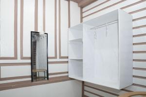 a white cabinet with a mirror and a chair at En Pensionne Comfort in Iloilo City