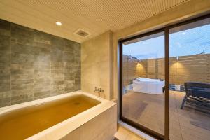 a bathroom with a large tub and a table at BETTEI in Oita +20 photos