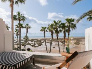 a room with a view of the beach and palm trees at Zel Fuerteventura in Costa Calma