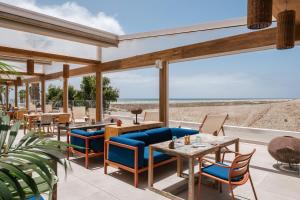 a patio with tables and chairs and a view of the beach at Zel Fuerteventura in Costa Calma