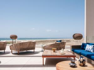 a living room with a couch and chairs and the beach at Zel Fuerteventura in Costa Calma