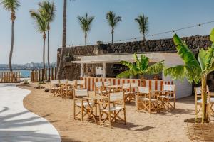 a row of tables and chairs on the beach at Paradisus Salinas Lanzarote - All Inclusive - Adults Only in Costa Teguise