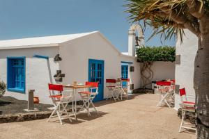 a table and chairs in front of a building at Paradisus Salinas Lanzarote - All Inclusive - Adults Only in Costa Teguise