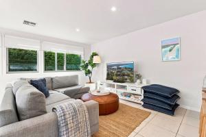 a living room with a couch and a tv at Coast Bliss on Currambene in Huskisson