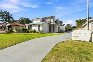 a large white house with a driveway at Coast Bliss on Currambene in Huskisson
