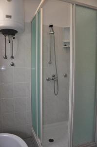 y baño con ducha y puerta de cristal. en Apartment Bilić, en Pula