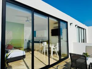 a room with large glass windows and a dining room at Studio RoofTop with amazing view in Mahahual