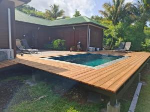 a deck with a swimming pool and a wooden deck at Chalet vue mer, piscine in Saint-Claude