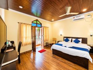 a bedroom with a bed and a desk and a television at Baga beach heritage resort in Calangute