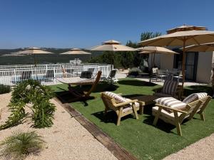 a patio with a table and chairs and umbrellas at סוויטות שריתא in Shomera