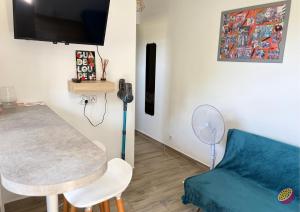 a living room with a table and a blue couch at Studio Belle Place in Le Gosier +8 photos